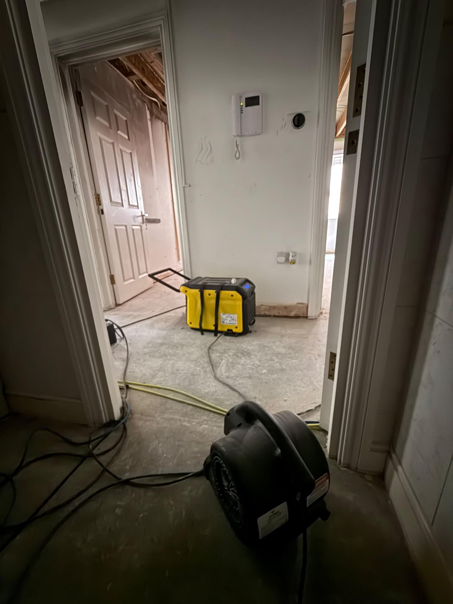 Portable drying equipment and an air mover on exposed floors during a Lite Response water-damage drying project